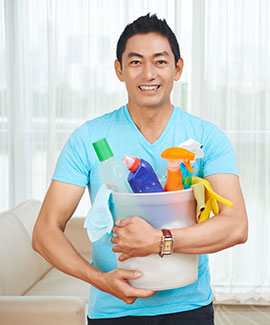 Portrait of smiling Vietnamese man with bucket of cleaning supplies